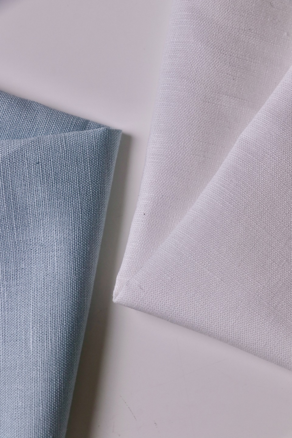 Blue and light-coloured fabric samples showing woven texture