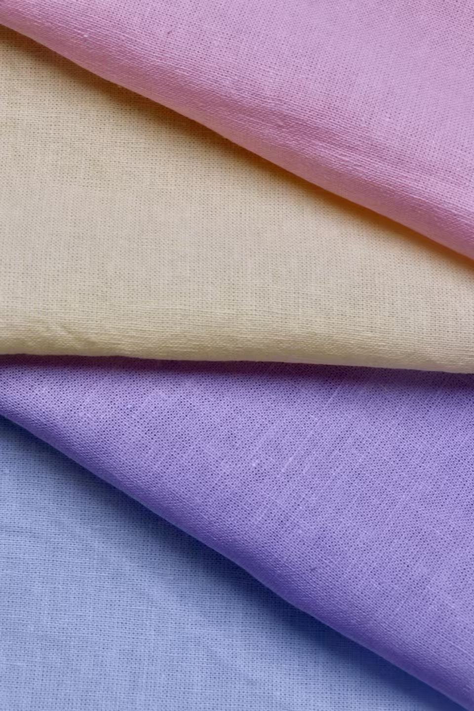 Pink, pale yellow, lilac and powder-blue fabric samples draped in layers