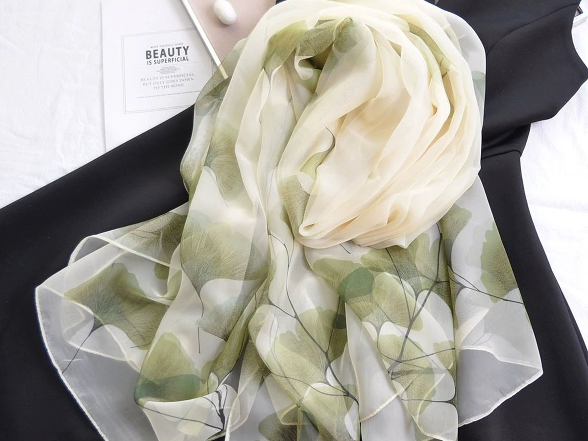 Light-coloured scarf with a leaf pattern, illustrating silk accessories